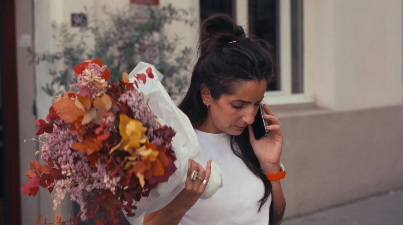 Alexia au téléphone, un bouquet de fleurs dans les bras