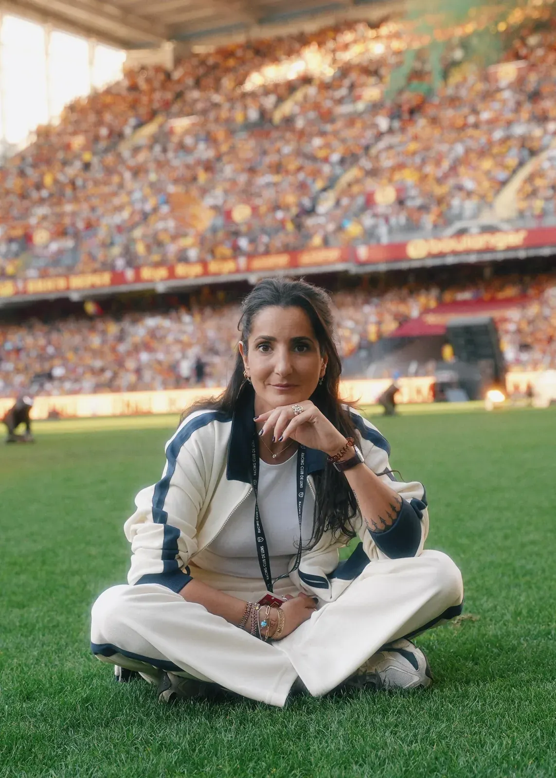 Alexia assise sur la pelouse d'un stade avant un concert